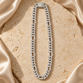 Cadena en tono plateado con grupos de eslabones cortos y eslabones alargados, cubierta de piedras transparentes y con cierre rectangular brillante.