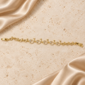 Una pulsera en tono dorado con cinco peces grandes de piedras transparentes, pequeños eslabones de pez y cierre plegable completo.