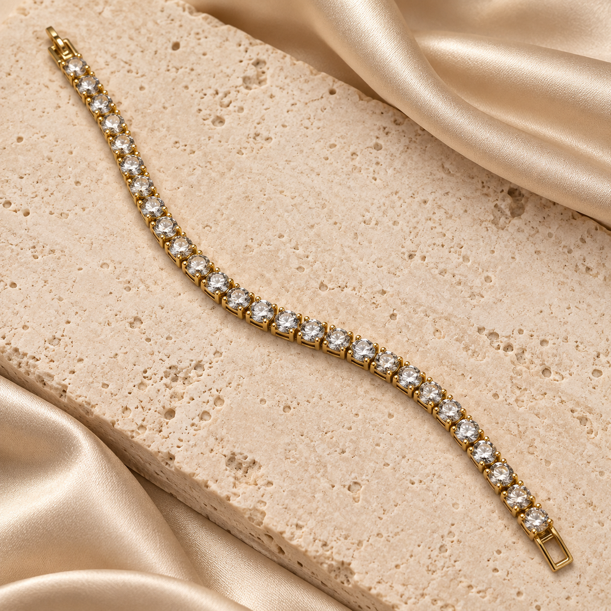 Pulsera estilo tennis en tono dorado con una hilera de piedras redondas transparentes y cierre rectangular.