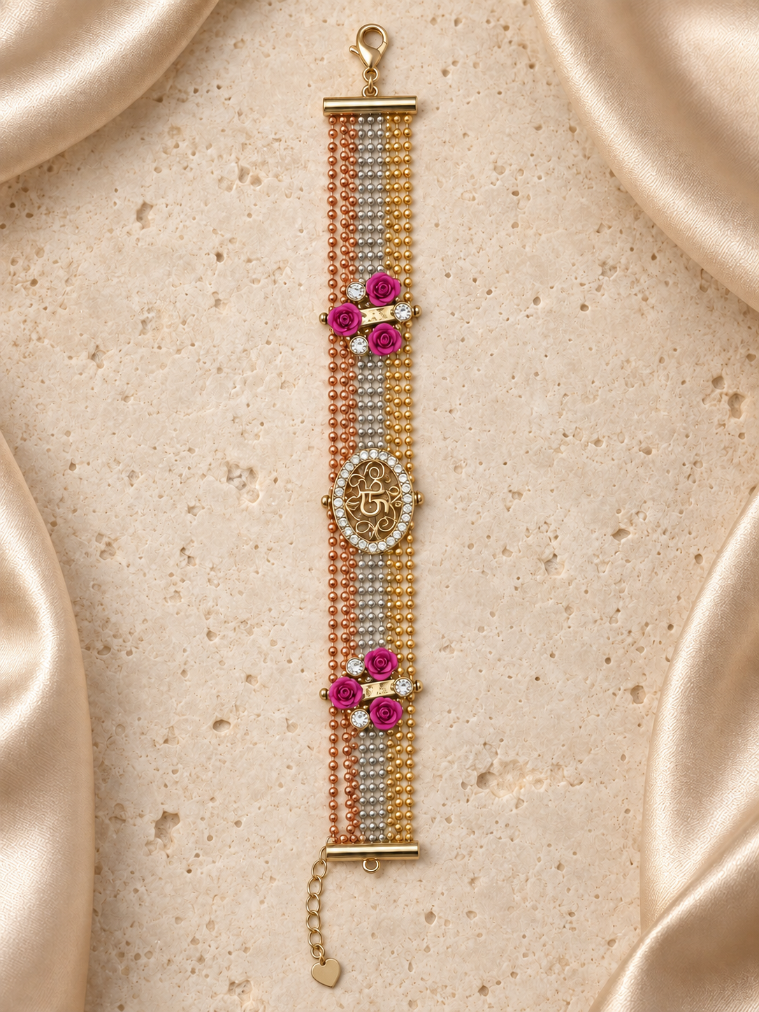 Una pulsera de cadenas de bolitas en tonos dorado, plateado y rosado, con medallón ovalado 15, seis rosas fucsias, cierre y cadena de extensión.