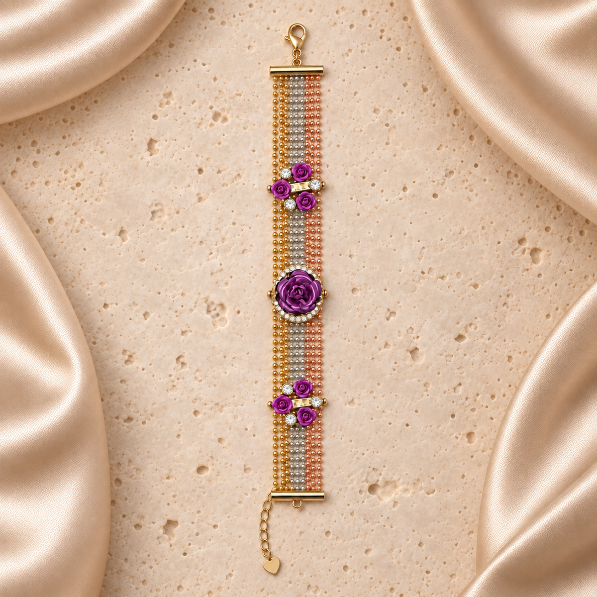 Una pulsera de cadenas en tres tonos, con siete rosas moradas, una rosa central grande rodeada de piedras transparentes, cierre y cadena de extensión.