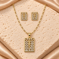 Set dorado de collar y aretes rectangulares con figura de Jesús en relieve y entramado de piedras transparentes.