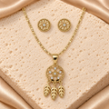 Collar en tono dorado con dije circular calado, seis piedras transparentes y tres plumas anchas colgantes, junto a dos aretes florales redondos.