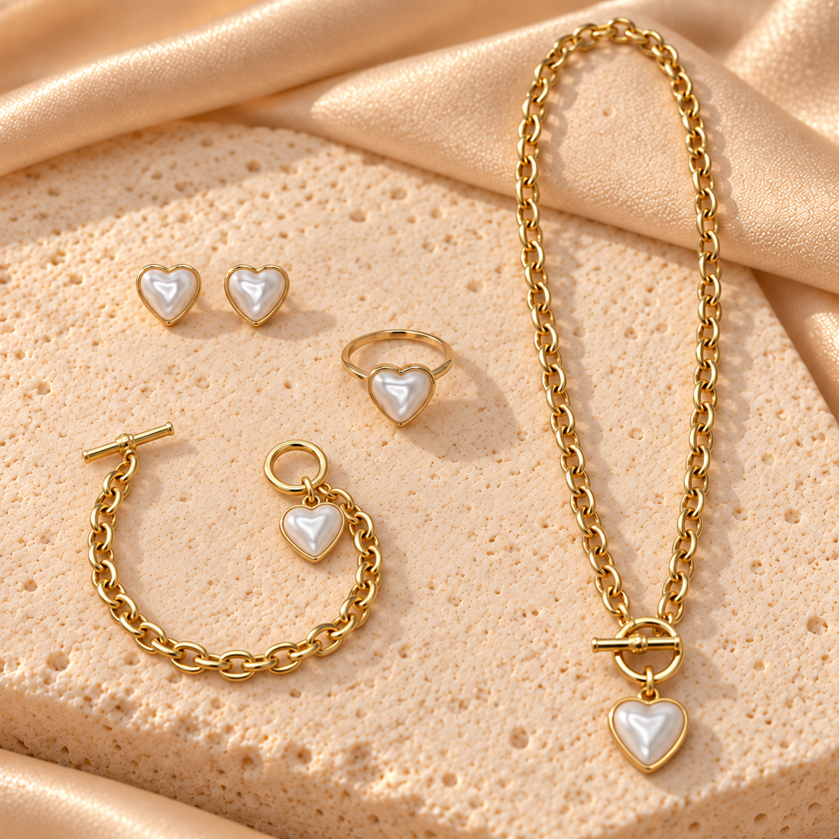 Set dorado con corazones blancos nacarados: un collar y una pulsera con cierre de barra y aro, dos aretes de corazón y un anillo.