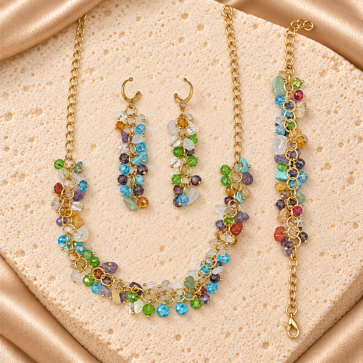 Set de collar, pulsera y aretes largos con cadenas doradas y cuentas colgantes multicolor, redondas facetadas y de formas irregulares.